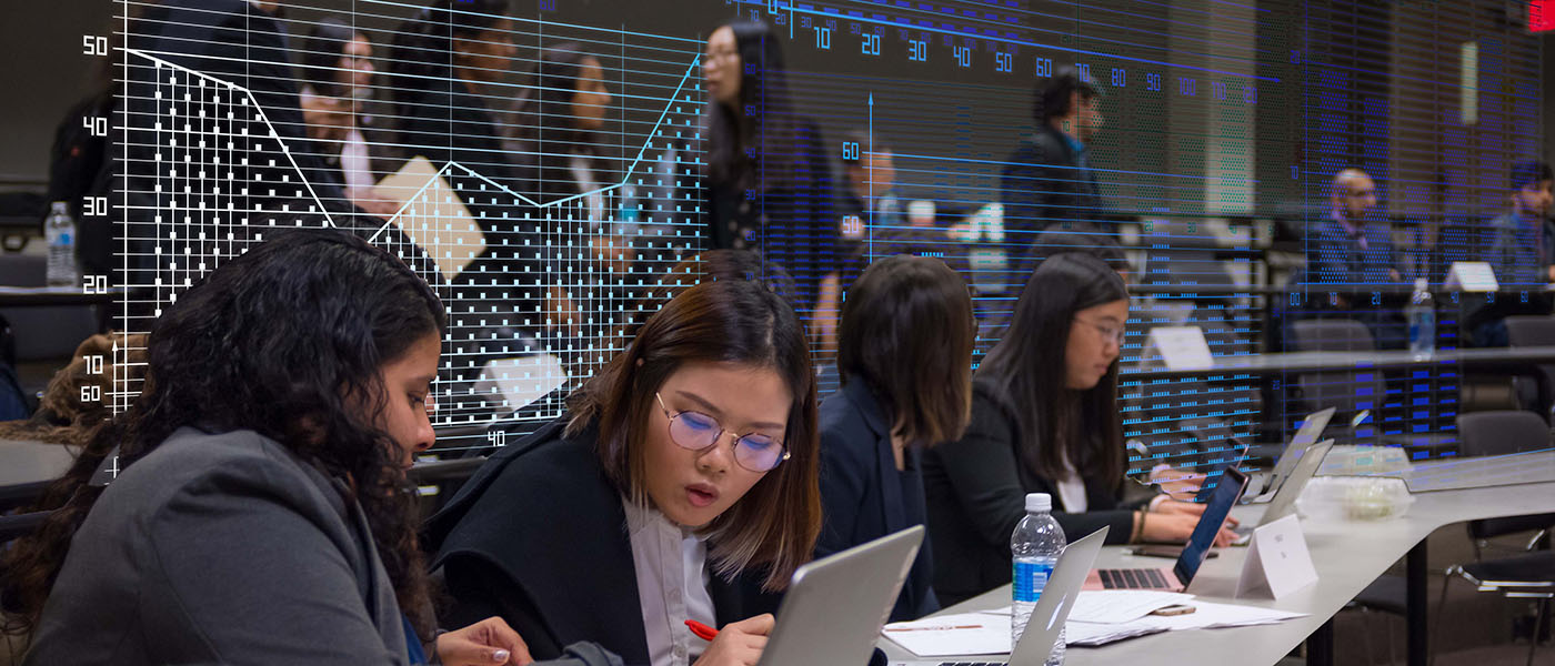 WPI Business School students working in a modern classroom with a financial and tech overlay